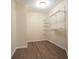 Empty walk-in closet featuring hardwood floors and wall-mounted shelving units at 465 Woodbrook Ways, Lawrenceville, GA 30043