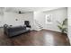 Spacious living room with hardwood floors, a cozy sofa, and a modern ceiling fan and staircase at 912 Ira Sw St, Atlanta, GA 30310