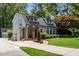 Charming two-story home featuring a stone-arched entry, a well-manicured lawn, and mature trees at 1195 Cameron Ct, Atlanta, GA 30306