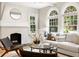 Bright living room with a decorative fireplace, arched windows, and stylish modern furniture at 1195 Cameron Ct, Atlanta, GA 30306
