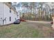 View of home's large backyard with mature trees, deck, and car at 2248 Bethel Rd, Conyers, GA 30012