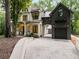 Beautiful stone house with a metal roof and an attached garage with an archway at 306 Pinecrest Ne Rd, Atlanta, GA 30342