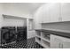 The laundry room features modern appliances, white cabinets, a dog washing station, and a black and white tile floor at 306 Pinecrest Ne Rd, Atlanta, GA 30342