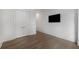 Open living room featuring hardwood floors, white walls, and mounted flatscreen TV at 306 Pinecrest Ne Rd, Atlanta, GA 30342