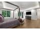 Bedroom with tray ceiling, hardwood floors, a four-poster bed, and windows with views at 306 Pinecrest Ne Rd, Atlanta, GA 30342