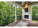 View of a covered patio with a fireplace and black metal railings overlooking a lush, green backyard at 306 Pinecrest Ne Rd, Atlanta, GA 30342