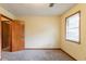 Bedroom showcasing carpeted floors, tan walls, natural light, and a door slightly open at 3440 Quinn Ridge Dr, Snellville, GA 30039