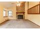 Living room with a stone fireplace, neutral carpet, and a large window providing natural light at 3440 Quinn Ridge Dr, Snellville, GA 30039