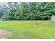 Expansive backyard with lush green lawn and mature trees providing shade and privacy at 3469 Stoneleigh Walk, Lithonia, GA 30038