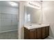 Bathroom featuring double vanity, a large mirror, and a walk-in closet with wire shelving at 3469 Stoneleigh Walk, Lithonia, GA 30038