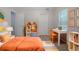 Bright bedroom featuring an orange decor, desk, and decorative bookshelf at 3469 Stoneleigh Walk, Lithonia, GA 30038