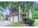 Two-story home with a brick facade, a two-car garage, and lush front yard landscaping at 3469 Stoneleigh Walk, Lithonia, GA 30038