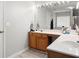 Bathroom featuring wood cabinets, white countertop, large mirror with lighting, and a shower/tub combo at 4003 Maple Ridge Nw Ln, Acworth, GA 30101