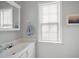 Bright bathroom featuring a sink with white countertops, a framed mirror, and a window providing natural light at 4003 Maple Ridge Nw Ln, Acworth, GA 30101
