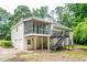 Back exterior showcasing a screened porch with walkout stairs and 2-car garage at 567 Leah Drive, Powder Springs, GA 30127