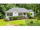 Charming ranch-style home with a well-manicured lawn, lush landscaping, and inviting front porch at 567 Leah Drive, Powder Springs, GA 30127