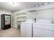 Functional laundry room featuring washing machine and dryer hookups, shelves, and unique vending machine at 567 Leah Drive, Powder Springs, GA 30127