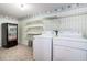 Well-lit laundry room equipped with a washing machine, dryer, shelving and snack machine at 567 Leah Drive, Powder Springs, GA 30127