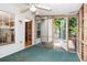 Enclosed screened porch featuring ceiling fan, wooden beams and trim, blue carpet, and exterior access to yard at 567 Leah Drive, Powder Springs, GA 30127
