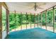 Sunroom with screened windows providing natural light and views of the backyard's lush trees at 567 Leah Drive, Powder Springs, GA 30127