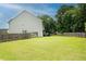 Large, grassy backyard enclosed by a wooden fence, surrounded by mature trees for privacy at 735 Sweethaven Ln, Loganville, GA 30052