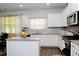 Bright kitchen with white cabinets, granite counters, stainless steel appliances and island at 735 Sweethaven Ln, Loganville, GA 30052