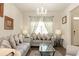 Cozy living room with a comfortable sofa, decorative pillows, and elegant chandelier at 735 Sweethaven Ln, Loganville, GA 30052