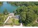This aerial view showcases a beautiful home with a well-manicured lawn near a lake, surrounded by lush greenery at 3441 Shoreland Dr, Buford, GA 30518