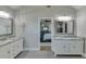 Bright bathroom with a double sink vanity, framed mirrors, and neutral-tone walls at 3441 Shoreland Dr, Buford, GA 30518