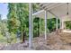 Expansive covered porch with stone flooring and a cozy fireplace, overlooking a private backyard at 3441 Shoreland Dr, Buford, GA 30518