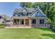 Charming two-story home boasts a brick facade, manicured lawn, and a welcoming front porch with rocking chairs at 3441 Shoreland Dr, Buford, GA 30518