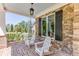 A cozy front porch features brick flooring, stone columns, and comfortable seating for relaxation and enjoying the outdoors at 3441 Shoreland Dr, Buford, GA 30518
