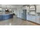 Open concept kitchen with white and dark blue cabinets and stainless steel appliances at 3441 Shoreland Dr, Buford, GA 30518