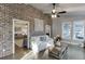 Bright living room with exposed brick wall, wood floors, and plenty of natural light creates a warm and inviting atmosphere at 3441 Shoreland Dr, Buford, GA 30518