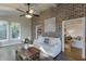 Bright living room with exposed brick wall, wood floors, and large windows creates a welcoming atmosphere with ample natural light at 3441 Shoreland Dr, Buford, GA 30518