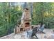 Inviting stone outdoor fireplace with built-in storage and flagstone patio, perfect for entertaining at 3441 Shoreland Dr, Buford, GA 30518