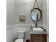 Stylish powder room with round mirror, vessel sink and wainscoting at 3441 Shoreland Dr, Buford, GA 30518
