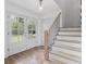 Bright foyer featuring hardwood floors, staircase with black iron railings, and stylish lighting, creating a welcoming ambiance at 3981 Longview Dr, Chamblee, GA 30341