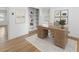 Home office with a wooden desk, hardwood floors, built-in bookshelves, and white paint at 3981 Longview Dr, Chamblee, GA 30341