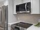 Modern kitchen featuring stainless steel appliances, stylish backsplash, and white cabinets for a clean and contemporary look at 3981 Longview Dr, Chamblee, GA 30341