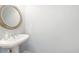 Half bathroom featuring a pedestal sink and round mirror at 4503 Kendall Way, Roswell, GA 30075