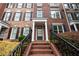 Brick townhouse with a black front door flanked by white columns and black shutters on windows at 4503 Kendall Way, Roswell, GA 30075