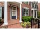 Inviting front porch with brick accents, white columns, and lush landscaping detailing the exterior of the home at 4503 Kendall Way, Roswell, GA 30075
