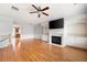 Bright living room with hardwood flooring, fireplace and built in shelving featuring modern ceiling fan at 4503 Kendall Way, Roswell, GA 30075
