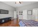 Bright bedroom with wood floors, large TV, and a collection of baseball caps on the wall at 5075 Havenbrooke Ct, Cumming, GA 30040