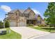 Charming stone and brick home with a two-car garage and well-manicured lawn at 5075 Havenbrooke Ct, Cumming, GA 30040