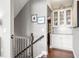 Bright hallway with a dark wood staircase, white cabinets, and granite countertops at 5075 Havenbrooke Ct, Cumming, GA 30040