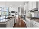 Modern kitchen features stainless steel appliances, granite countertops, and an open concept layout to the living area at 5075 Havenbrooke Ct, Cumming, GA 30040