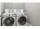 Efficient laundry room features a front load washer and dryer, plus upper shelving at 5075 Havenbrooke Ct, Cumming, GA 30040