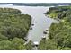 Aerial view of properties along a lake, featuring private docks and surrounded by lush forest at 609 Redwood Drive Dr, Woodstock, GA 30189